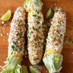 Three Mexican Street Corn (Elotes) on wooden board