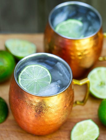 Moscow Mule Cocktail in copper mugs with sliced lime and ice