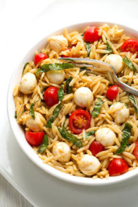 Caprese Orzo Salad in a white bowl on a white plate