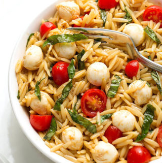 Caprese Orzo Salad in a white bowl on a white plate