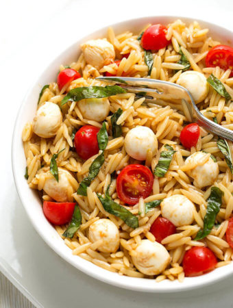 Caprese Orzo Salad in a white bowl on a white plate