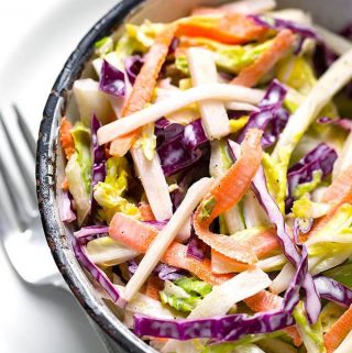 This Easy Creamy Coleslaw recipe is a tasty coleslaw with a creamy, tangy-sweet dressing. We like putting this coleslaw on top of pulled pork sandwiches. simplyhappyfoodie.com #coleslaw #coleslawrecipe creamy coleslaw recipe