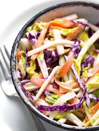 Creamy Coleslaw in a bowl on a plate with silver fork