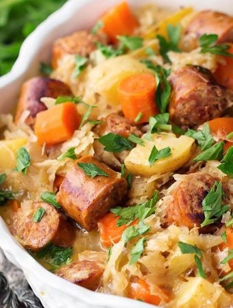 Instant Pot Kielbasa and Sauerkraut in a white bowl garnished with parsley