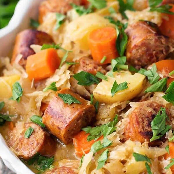 Instant Pot Kielbasa and Sauerkraut in a white bowl garnished with parsley