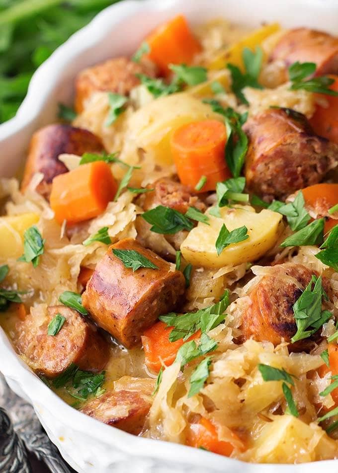 Instant Pot Kielbasa and Sauerkraut in a white bowl garnished with parsley