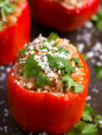 Three red Mexican Stuffed Peppers on dark background