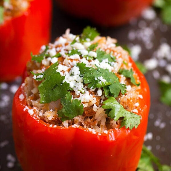 Three red Mexican Stuffed Peppers on dark background