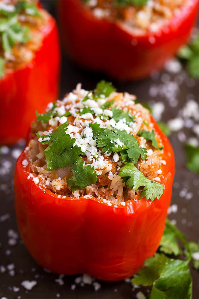 Three red Mexican Stuffed Peppers on dark background