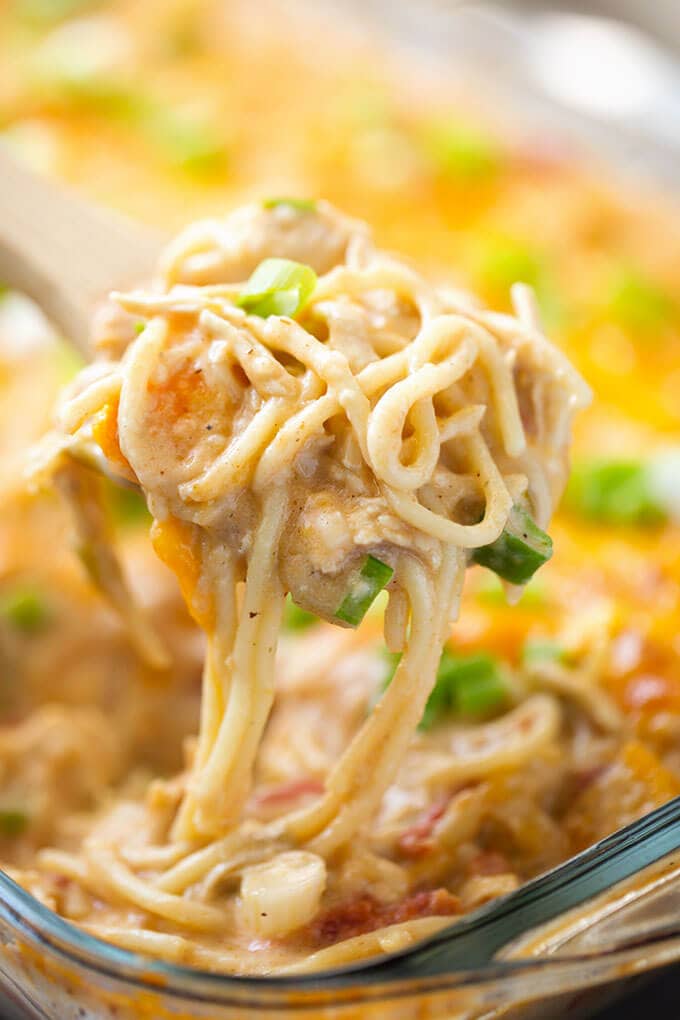 Close up of scoop of Creamy and Cheesy Baked Chicken Spaghetti on wooden spoon
