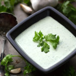 Cilantro Cream Dressing in small square black bowl garnished with cilantro