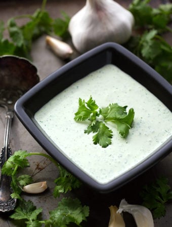 Cilantro Cream Dressing in small square black bowl garnished with cilantro