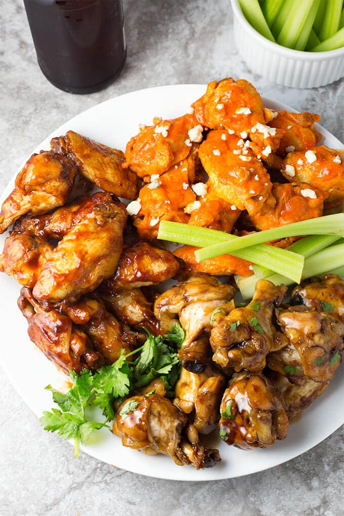 Three types of Instant Pot Chicken Wings on a white plate with celery