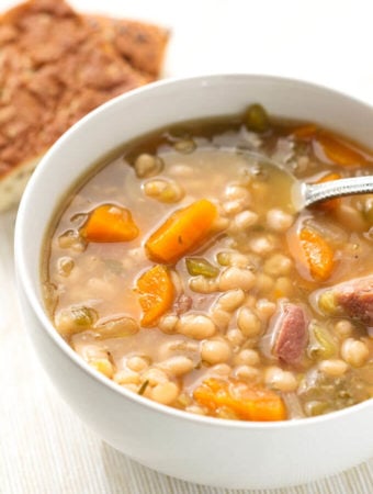 Instant Pot Ham Hock and Bean Soup in a white bowl with spoon