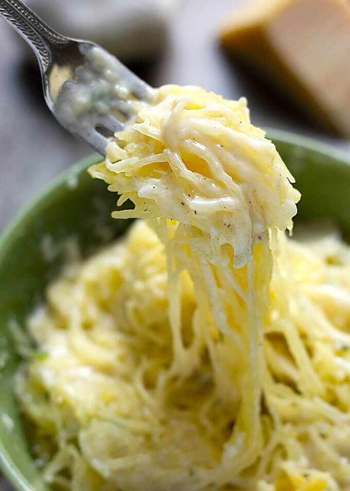 close up of forkful of Spaghetti Squash in green bowl