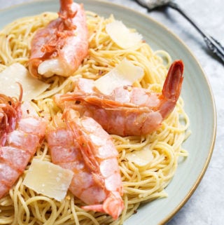 Lemony Capellini with Shrimp on a white plate with fork in the background