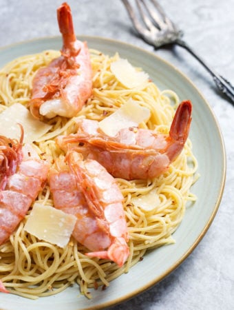 Lemony Capellini with Shrimp on a white plate with fork in the background