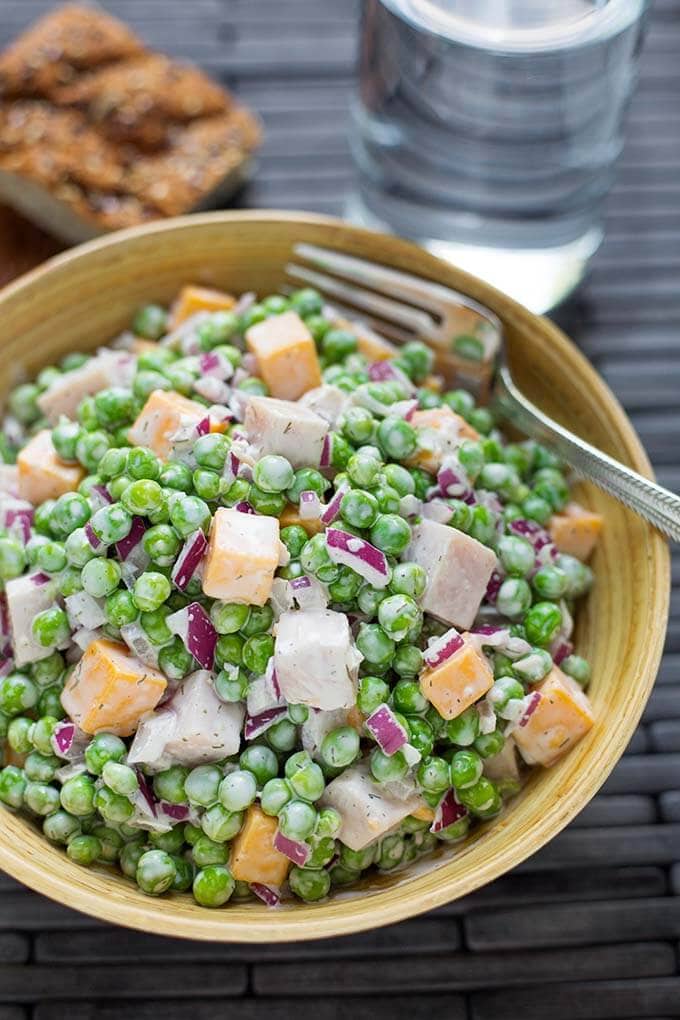 Pea Salad with Smoked Turkey in a dark yellow bowl with a silver fork