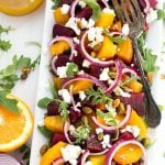 Beet Salad with Goat Cheese and Orange Vinaigrette on white rectangular plate with silver fork