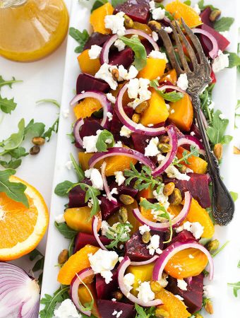 Beet Salad with Goat Cheese and Orange Vinaigrette on white rectangular plate with silver fork