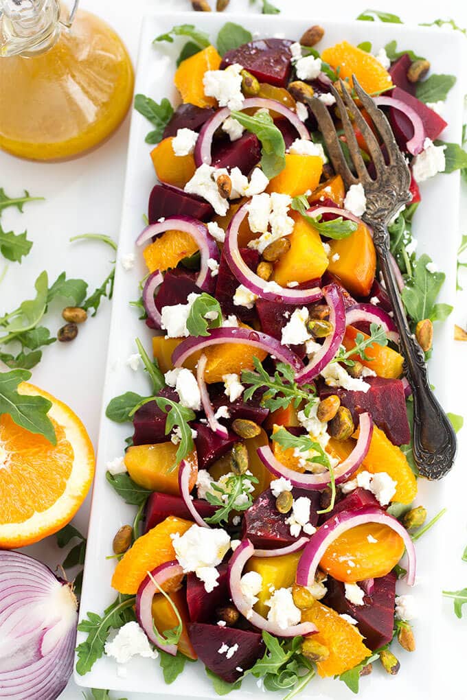 Beet Salad with Goat Cheese and Orange Vinaigrette on white rectangular plate with silver fork