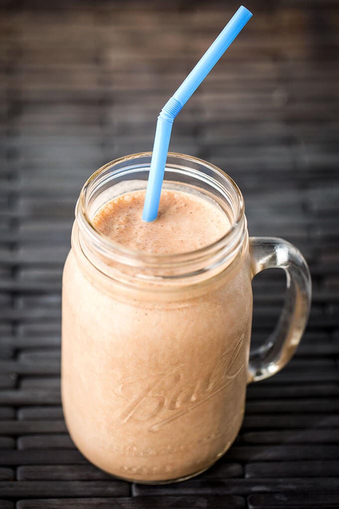 Chocolate Peanut Butter Banana Smoothie in glass ball jar with blue straw