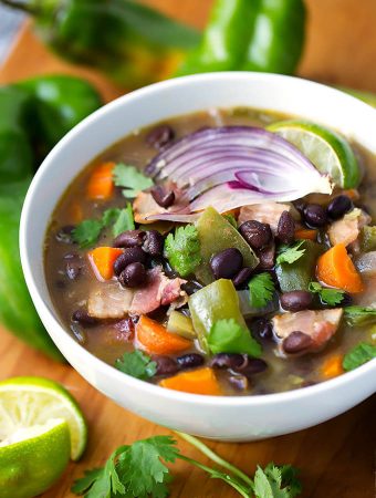 Hatch Green Chile Black Bean Soup in a white bowl on a wooden board