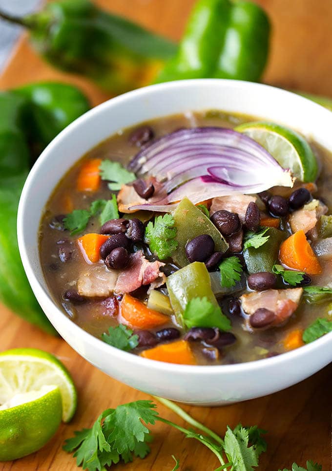 Hatch Green Chile Black Bean Soup in a white bowl on a wooden board