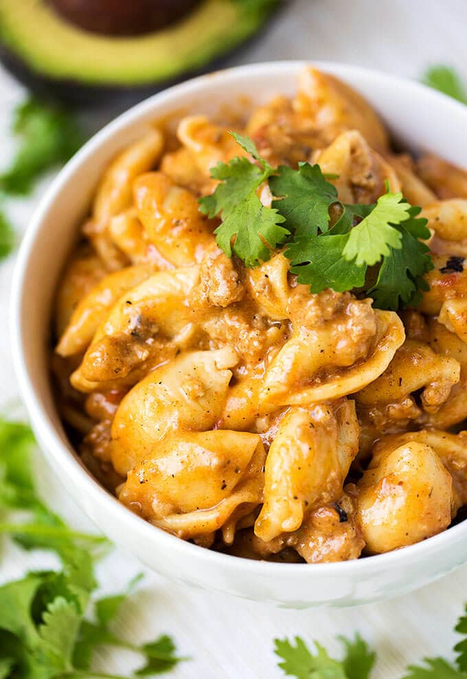 Instant Pot Cheesy Taco Pasta in a white bowl garnished with cilantro