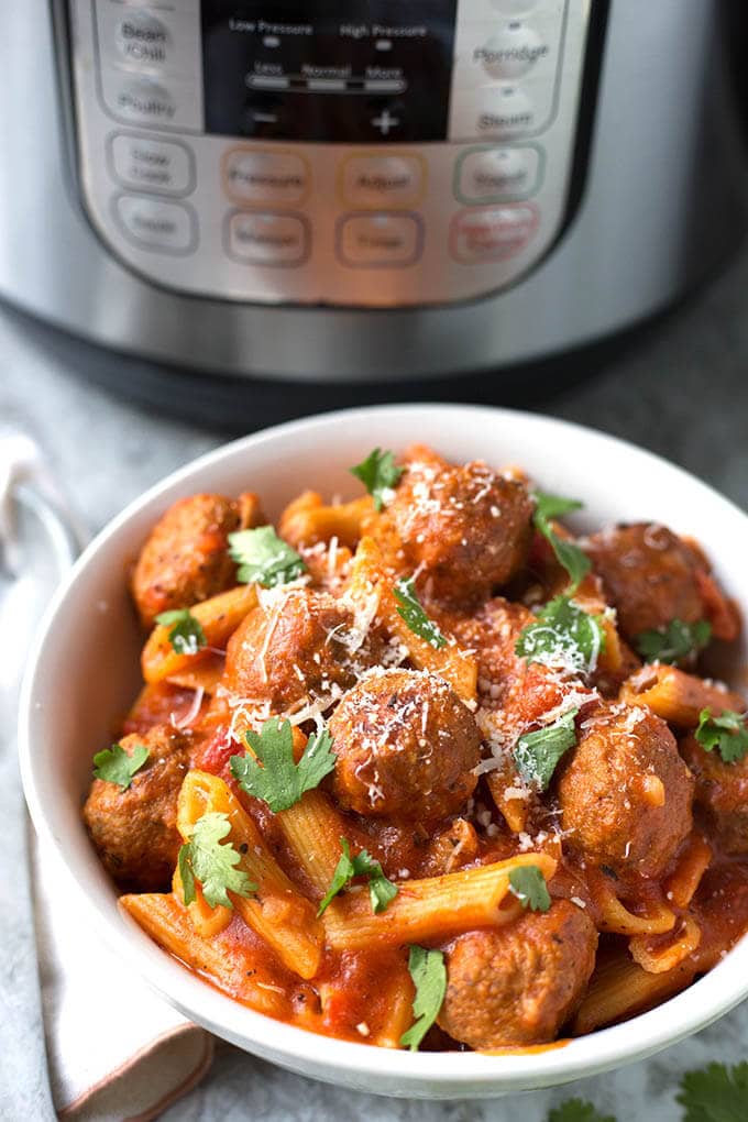 Instant Pot Meatball Pasta Dinner in a white bowl with pressure cooker in background