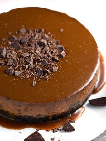 Whole chocolate cheesecake on white plate