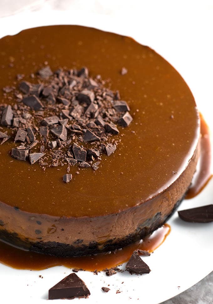 Whole chocolate cheesecake on white plate