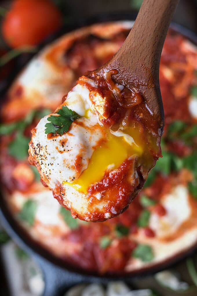 Close up of wooden spoon with Shakshouka - Eggs in Purgatory 