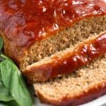Tasty Turkey Meatloaf on white plate next to baby spinach