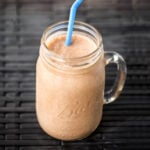 Chocolate Peanut Butter Banana Smoothie in glass Ball jar with blue straw