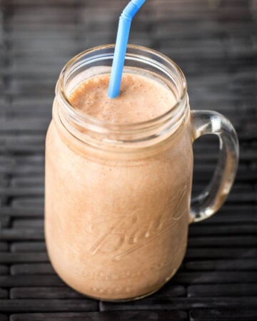 Chocolate Peanut Butter Banana Smoothie in glass Ball jar with blue straw