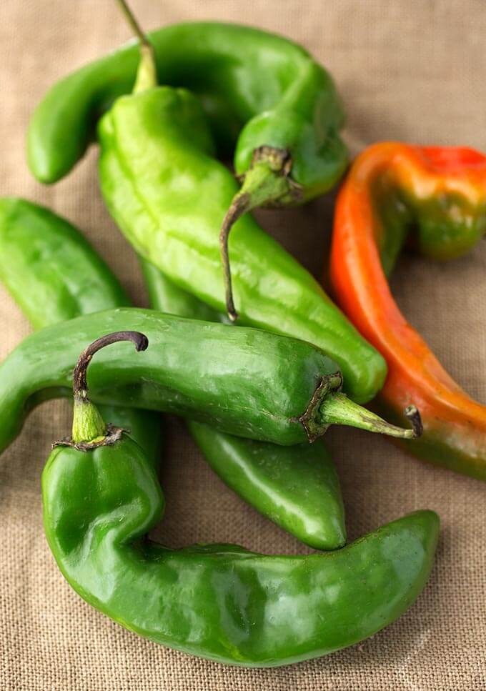 Green hatch chiles on brown fabric background 