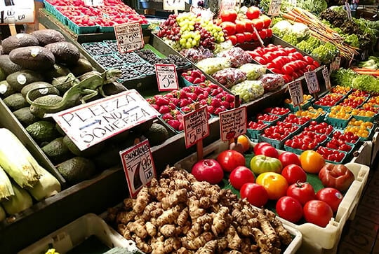 Pike Place Market Produce display with a large green lizard on top of avocados