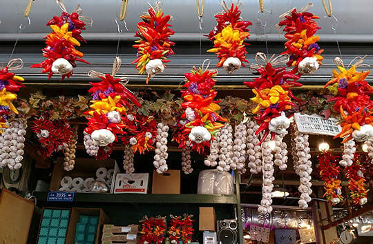 Pike Place Market Produce with several hanging chili and garlic garlands