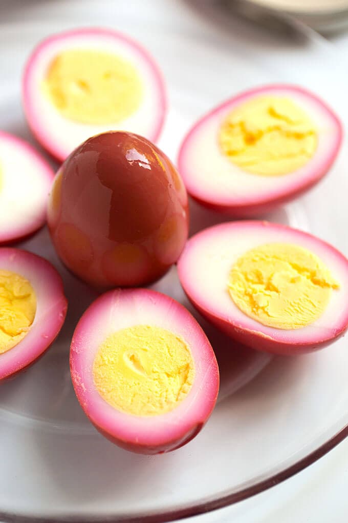 Halved pickled eggs on white plate with yoke side up