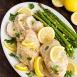 Creamy Lemon Chicken with asparagus on a white oblong plate on wooden table