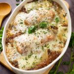 French Onion Chicken and Rice in a white oval shaped bowl on a small wooden board