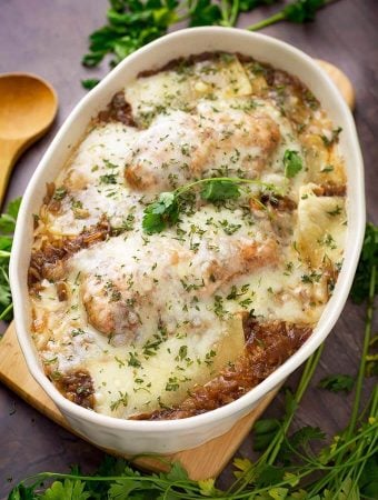 French Onion Chicken and Rice in a white oval shaped bowl on a small wooden board