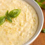 Polenta in a white bowl on wooden board