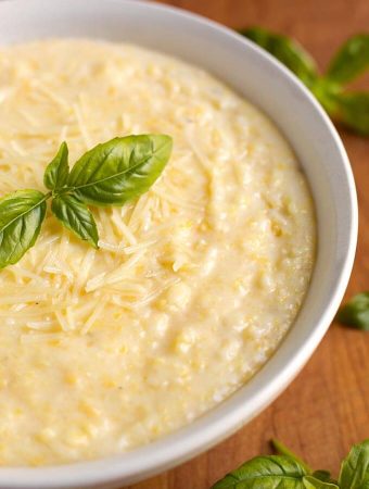 Polenta in a white bowl on wooden board