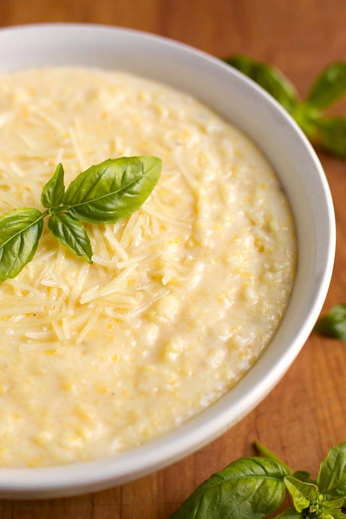 Polenta in a white bowl on wooden board