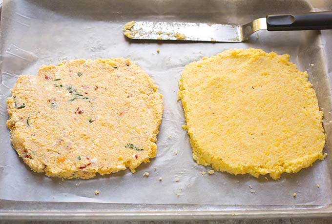 Polenta spread out on wax paper on a baking sheet