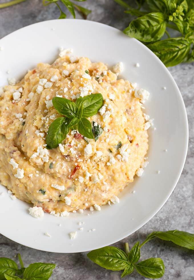 Polenta on a white plate garnished with basil