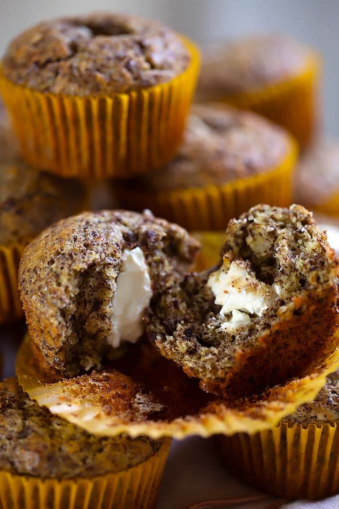 Close up of split Chocolate Cream Cheese Muffin with more muffins stacked in the background