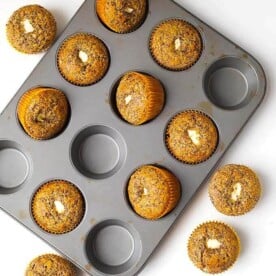 Orange Chocolate Cream Cheese Muffins in a muffin pan on a white background